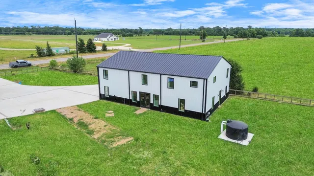 a aerial view of a house with a yard and a patio
