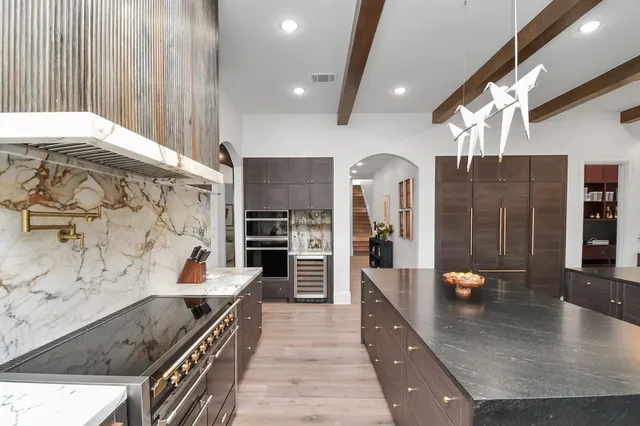 a large kitchen with stainless steel appliances granite countertop a granite counter tops and a view of living room