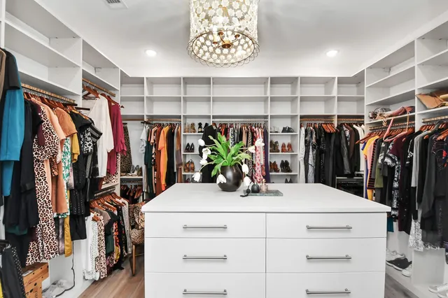 a view of walk in closet with clothes