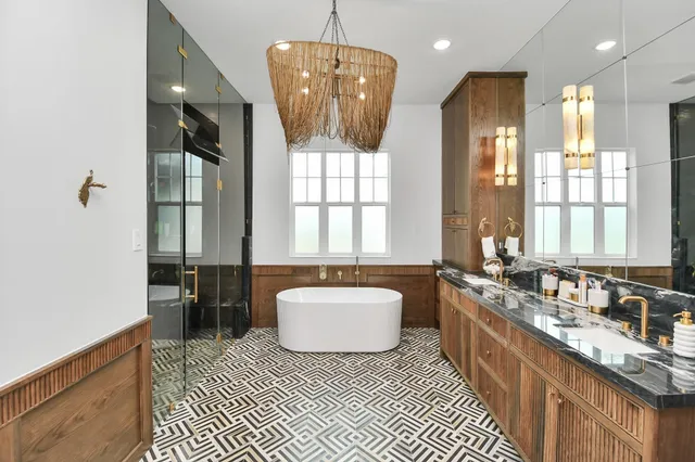 a spacious bathroom with a double vanity sink a mirror and a bathtub
