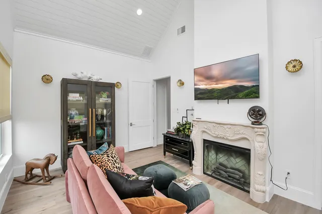 a living room with furniture a flat screen tv and a fireplace