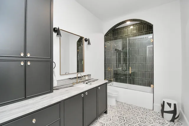 a bathroom with a sink a toilet and shower