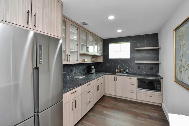 a kitchen with stainless steel appliances granite countertop a refrigerator and a sink