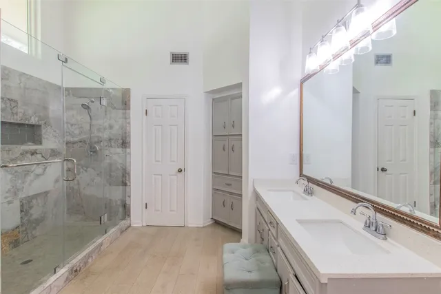 a bathroom with a bathtub sink vanity granite and shower