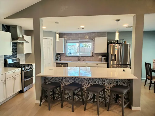 a kitchen with kitchen island granite countertop a table and chairs in it