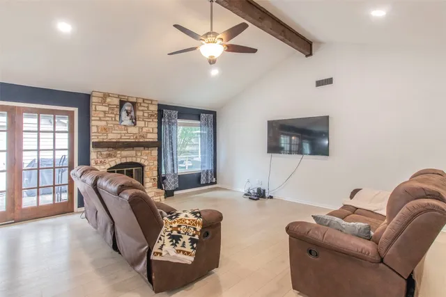 a living room with furniture fireplace and a large window