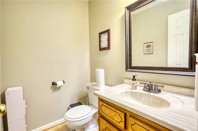 a bathroom with a granite countertop sink toilet and a mirror
