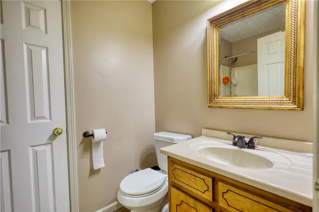 a bathroom with a granite countertop sink toilet and mirror