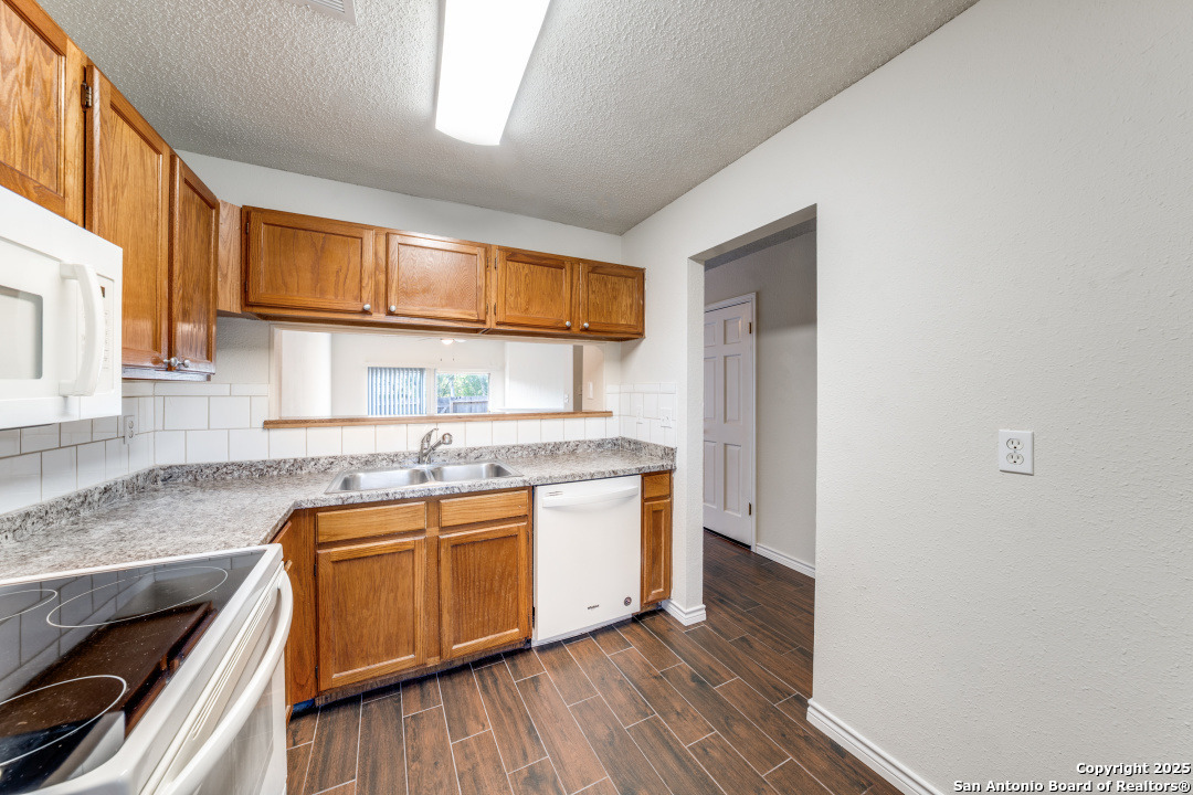 10254 Dover Ridge, Unit 204 San Antonio, TX 78250 - Photo 15 of 31 a kitchen with stainless steel appliances granite countertop a stove and a sink