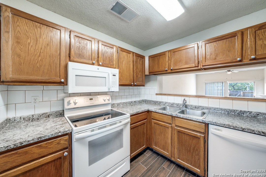 10254 Dover Ridge, Unit 204 San Antonio, TX 78250 - Photo 17 of 31 a kitchen with stainless steel appliances granite countertop a sink stove and cabinets