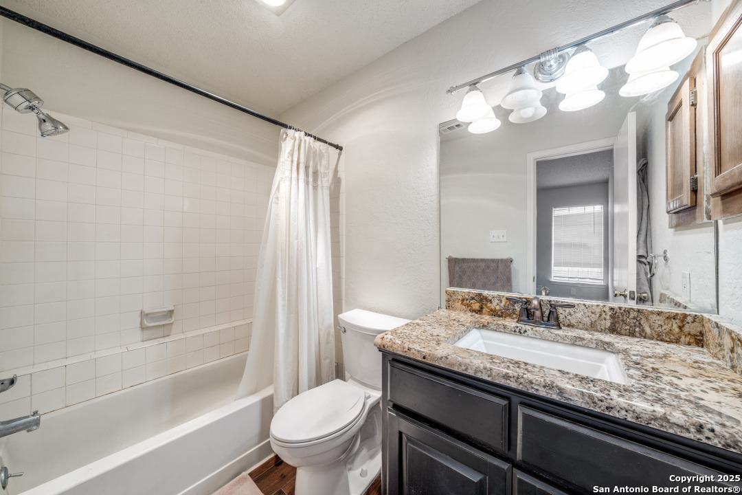 10254 Dover Ridge, Unit 204 San Antonio, TX 78250 - Photo 21 of 31 a bathroom with a granite countertop sink toilet and shower