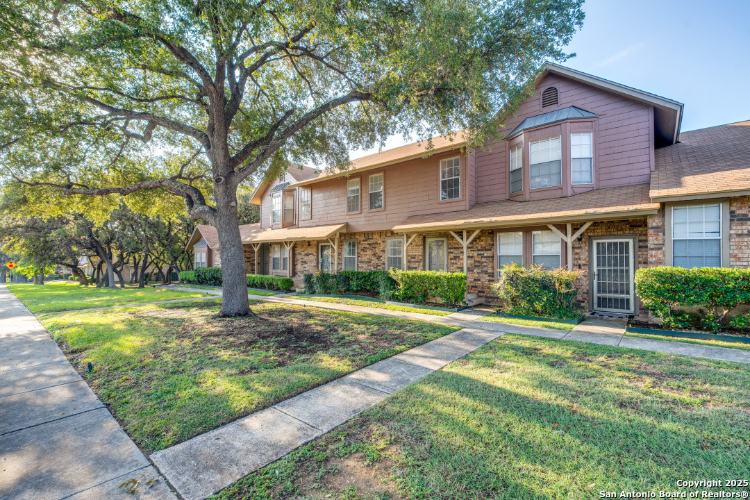 10254 Dover Ridge, Unit 204 San Antonio, TX 78250 - Photo 3 of 31 a front view of a house with a yard and trees