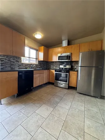 a view of a kitchen with a sink and a refrigerator
