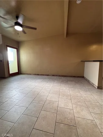 en empty room with windows and ceiling fan