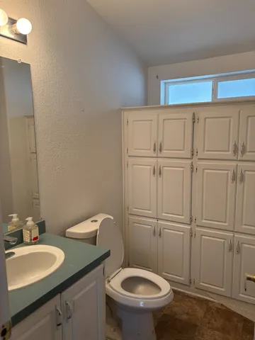 a bathroom with a sink a toilet and a mirror