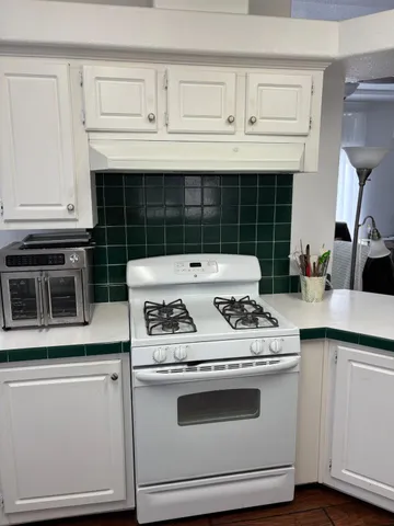 a stove top oven sitting inside of a kitchen