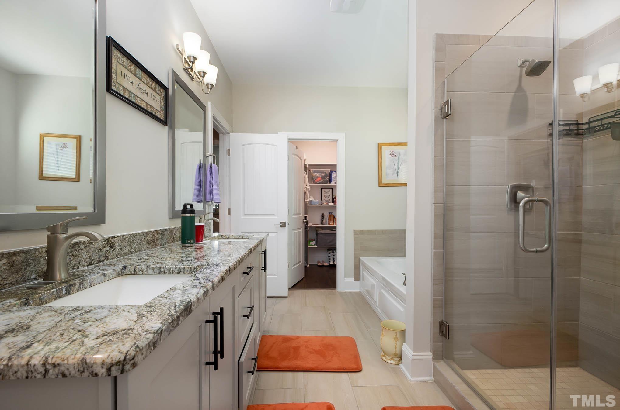 8801 Rainer Way Wake Forest, NC 27587 - Photo 15 of 34 a bathroom with a granite countertop sink a mirror and shower