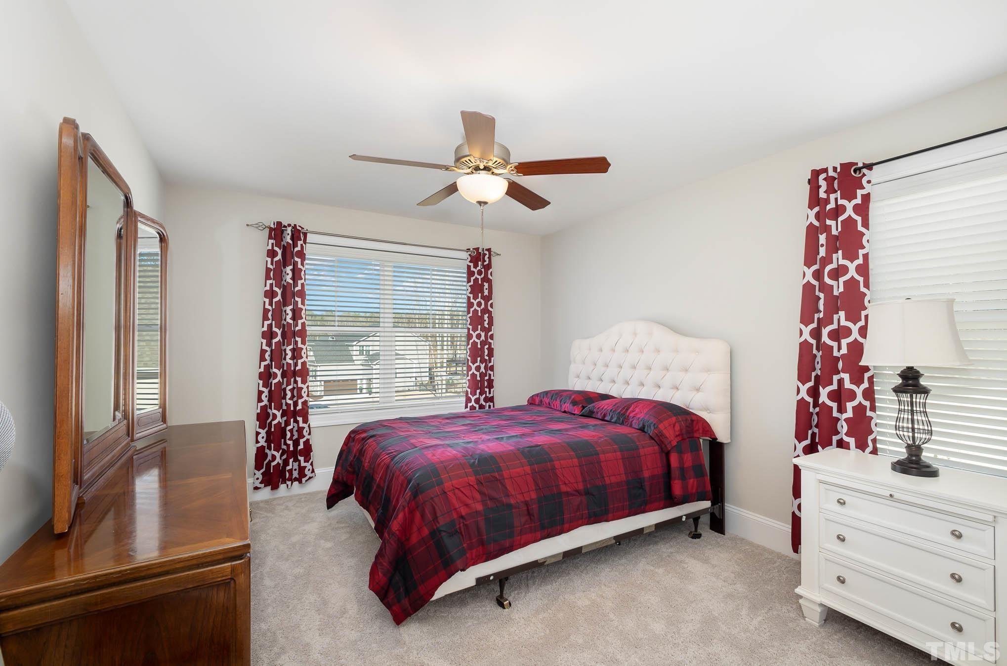 8801 Rainer Way Wake Forest, NC 27587 - Photo 19 of 34 a bedroom with a bed and a chandelier