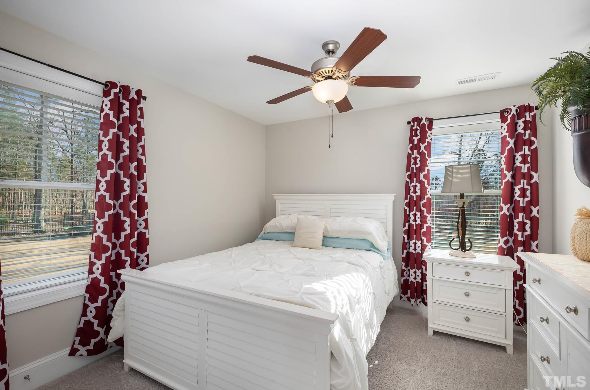 8801 Rainer Way Wake Forest, NC 27587 - Photo 20 of 34 a bedroom with a bed and a chandelier
