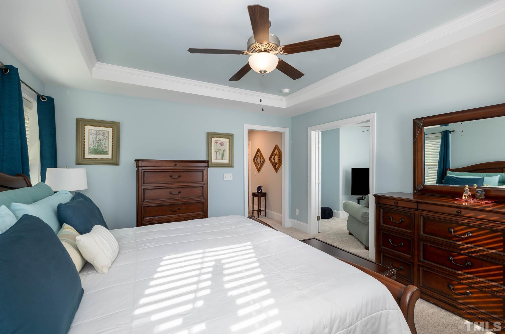 8801 Rainer Way Wake Forest, NC 27587 - Photo 23 of 34 a bedroom with a bed and a chandelier