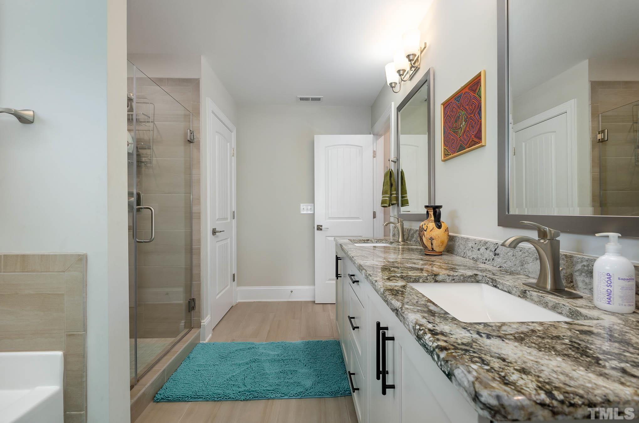 8801 Rainer Way Wake Forest, NC 27587 - Photo 25 of 34 a bathroom with a granite countertop sink and a mirror