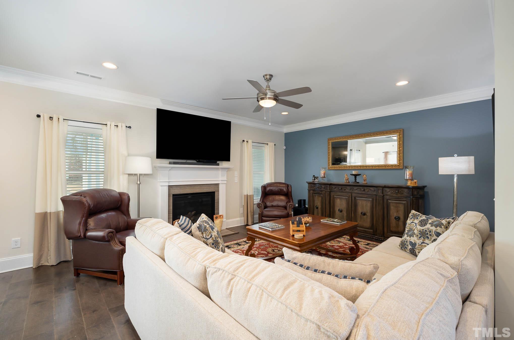 8801 Rainer Way Wake Forest, NC 27587 - Photo 6 of 34 a living room with furniture a fireplace and a flat screen tv
