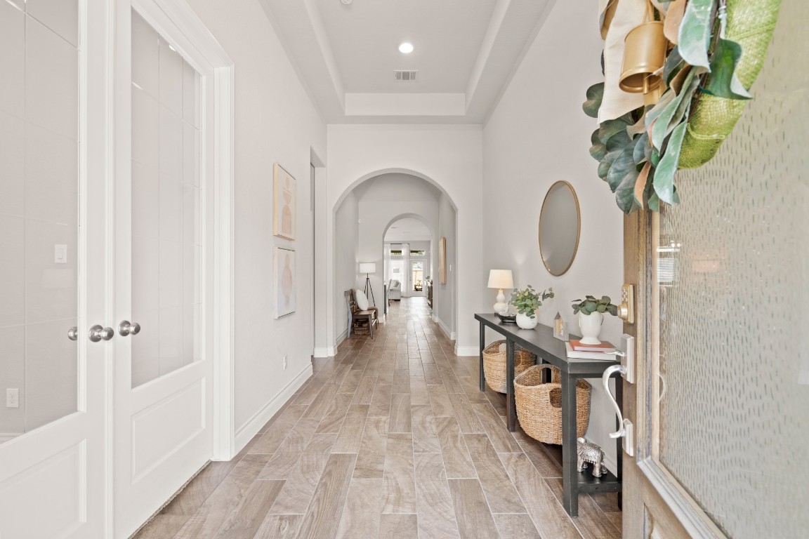 6918 Goldstrum Way Katy, TX 77493 - Photo 2 of 27 a view of a hallway with wooden floor and a chandelier