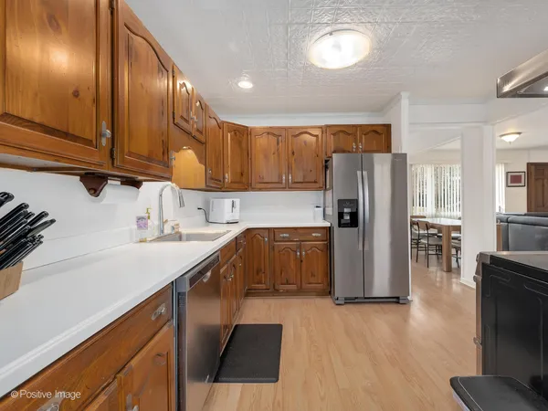 a kitchen with a sink a refrigerator and wooden floor