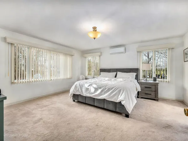 a spacious bedroom with a bed and a window