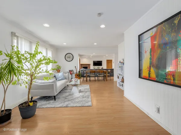 a living room with furniture and potted plants with kitchen view