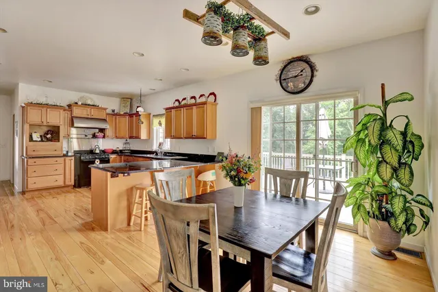 a large kitchen with stainless steel appliances a table and chairs in it