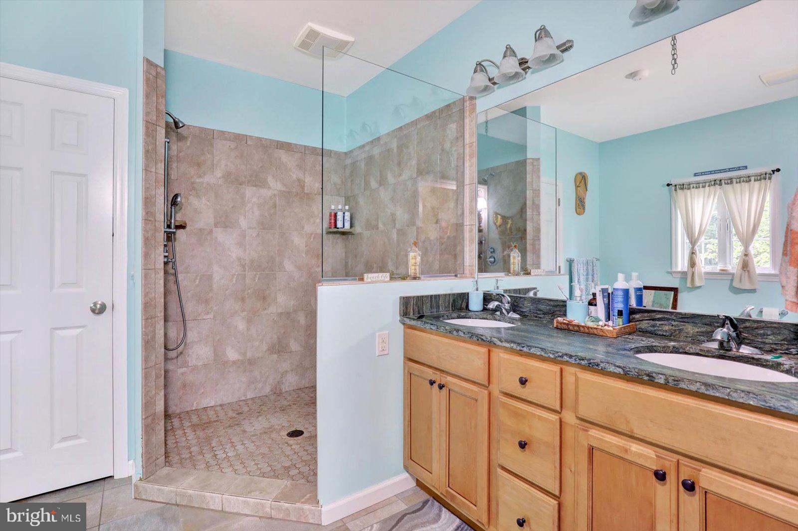 1881 Georgetown Road Christiana, PA 17509 - Photo 34 of 45 a bathroom with a granite countertop sink a mirror a shower and a bathtub
