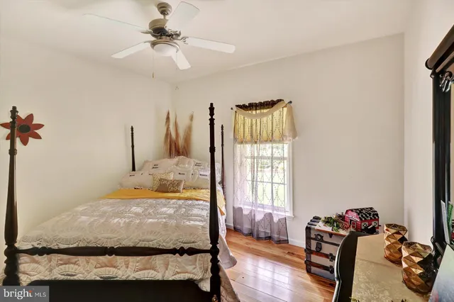 a very nice looking room with wooden floor and ceiling fan