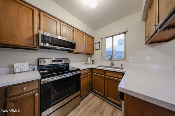 a kitchen with stainless steel appliances granite countertop wooden cabinets granite counter tops and a window