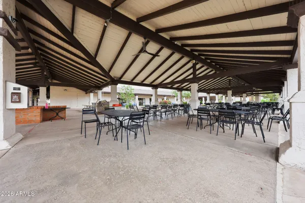 a view of a patio with a table and chairs under an umbrella