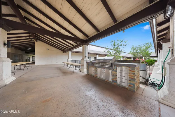 a view of a patio with table and chairs under an umbrella