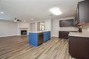 a kitchen with stainless steel appliances granite countertop a sink cabinets and wooden floor