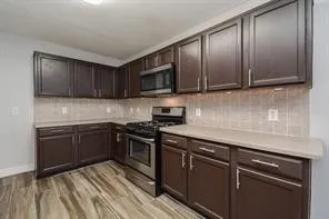 a kitchen with granite countertop wooden cabinets and stainless steel appliances