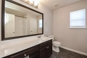 a bathroom with a sink a toilet and a window