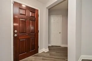 a view of a hallway with wooden floor
