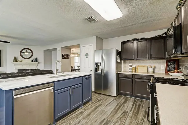a kitchen with stainless steel appliances granite countertop a stove refrigerator sink and microwave