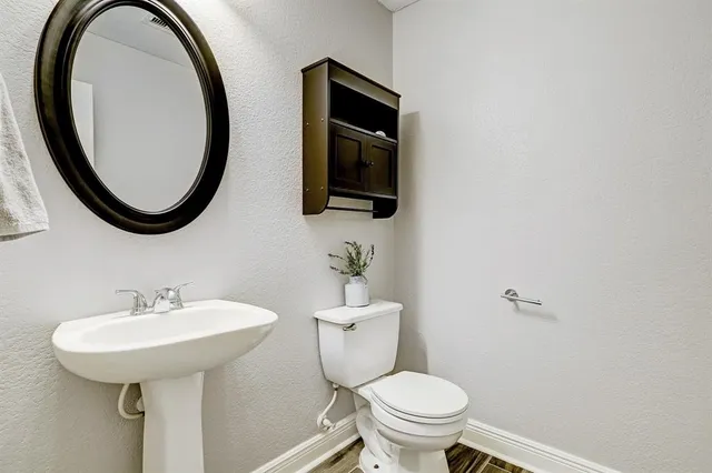 a bathroom with a toilet a sink and a mirror