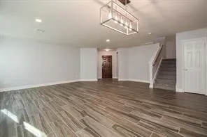wooden floor in an empty room with a chandelier