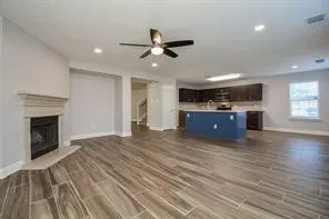 an empty room with wooden floor fireplace and windows