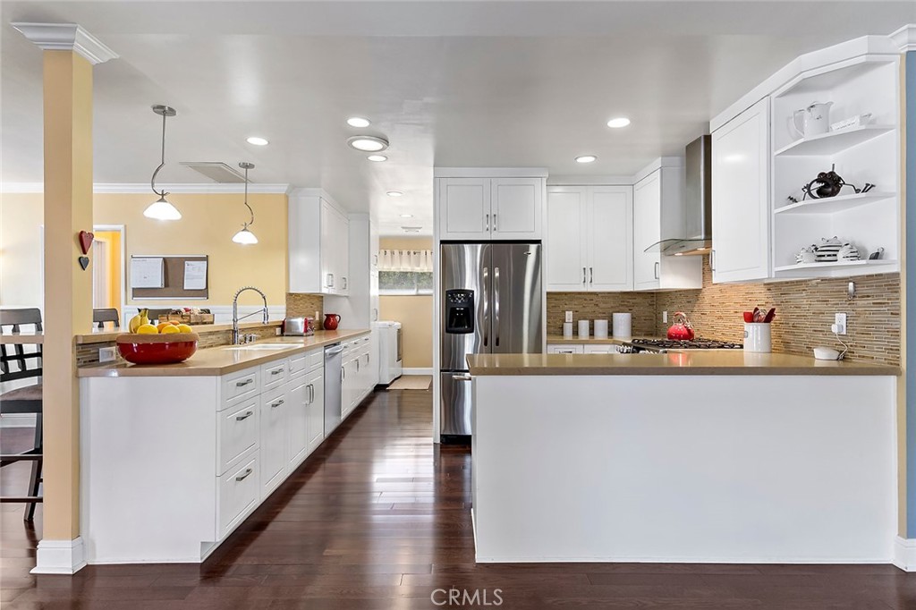 2818 Ostrom Avenue Long Beach, CA 90815 - Photo 8 of 41 a large kitchen with stainless steel appliances lots of counter space and wooden floor