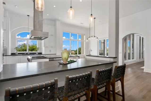 a kitchen with stainless steel appliances granite countertop a sink a stove and a wooden floors