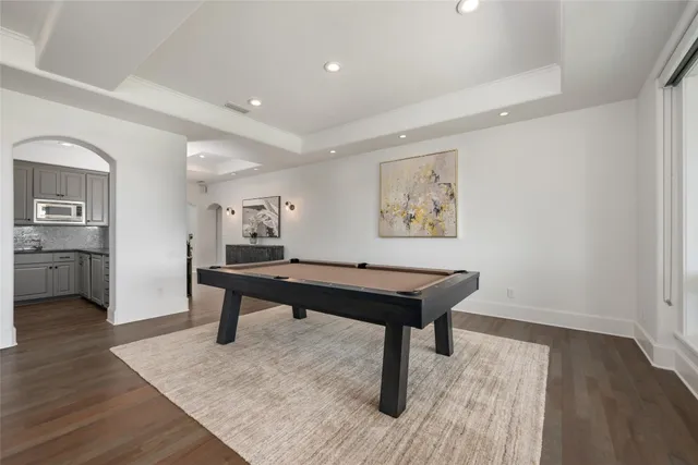 a room with furniture pool table and wooden floor