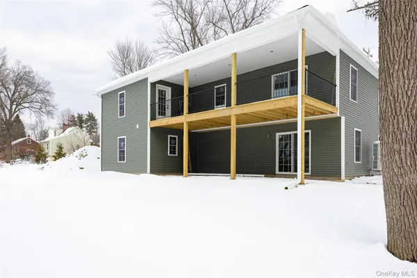 a front view of a house with a yard covered in snow