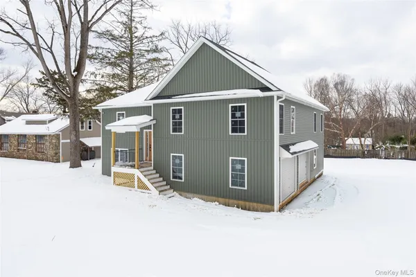 a view of a house with a yard covered in snow