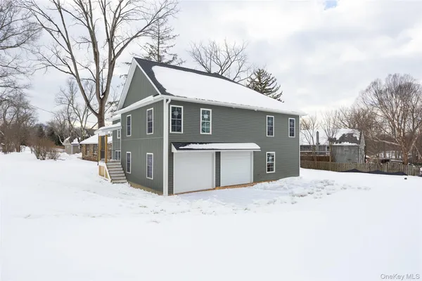 a front view of a house with a yard covered in snow